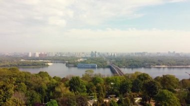 Ukrayna, Kyiv 'in merkezi. Köprüler bayrak işaretleri, konut binaları, nehir, metro insansız hava aracı manzarası.