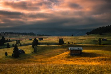 Dolomitlerdeki Seiser Alm dağ çayırında bulutlu bir gün doğumu