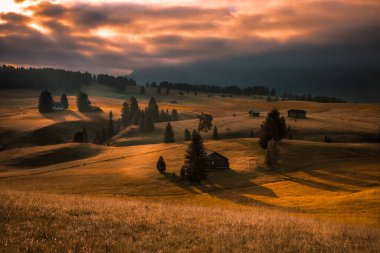Dolomitlerdeki Seiser Alm dağ çayırında bulutlu bir gün doğumu