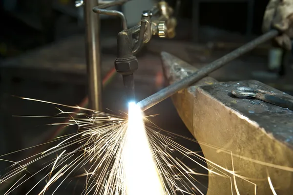 Metal fabricator utilizing a torch to heat up a piece of metal — Stock Photo, Image