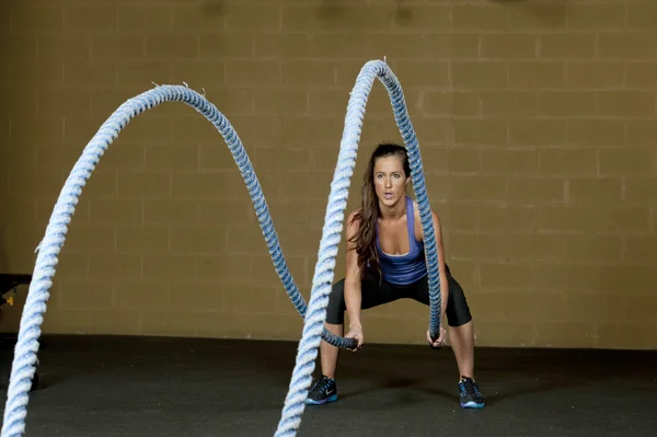 Entrenamiento de mujer con cuerdas de entrenamiento atlético —  Fotos de Stock