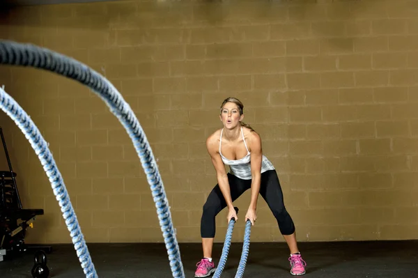 Entrenamiento de mujer con cuerdas de entrenamiento atlético — Foto de Stock