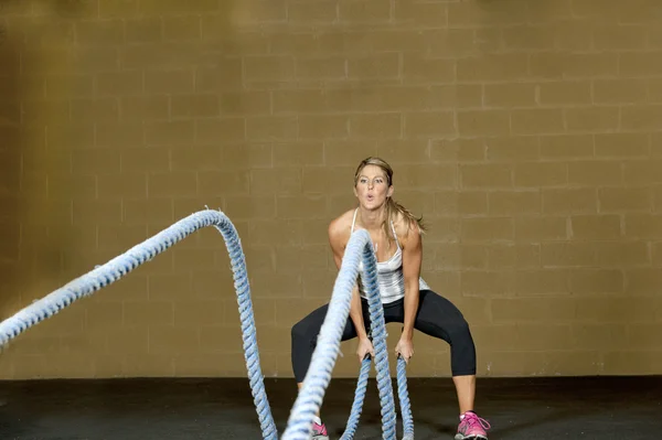 Entrenamiento de mujer con cuerdas de entrenamiento atlético — Foto de Stock