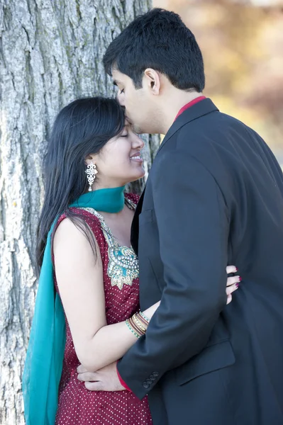 Un joven indio feliz besando a su novia en la frente — Foto de Stock