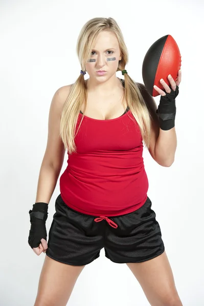 Modelo feminino segurando um futebol vermelho e preto — Fotografia de Stock