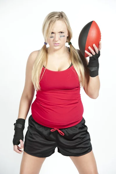 Modelo feminino segurando um futebol vermelho e preto — Fotografia de Stock