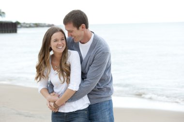 Genç bir çift sahilde yürüyor.