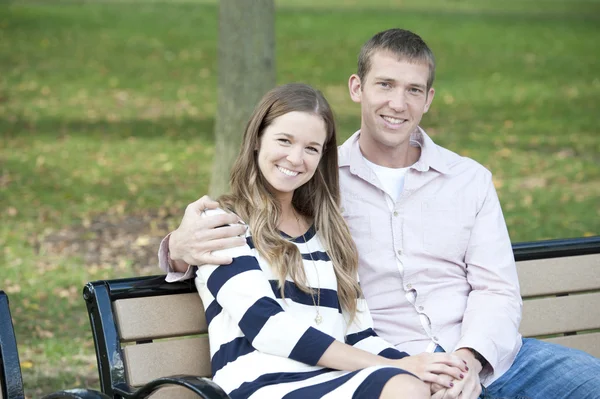 Couple sitting on a bench at the park — Stock Photo, Image