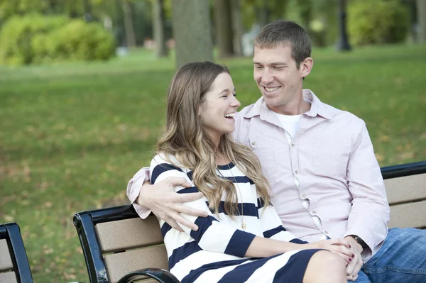 Couple sitting on a bench at the park — Stock Photo, Image