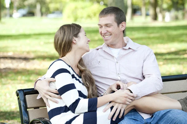 Couple sitting on a bench at the park — Stock Photo, Image