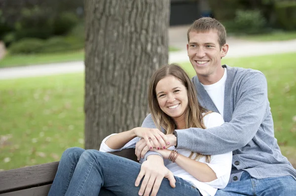 Couple sitting on a bench at the park — Stock Photo, Image