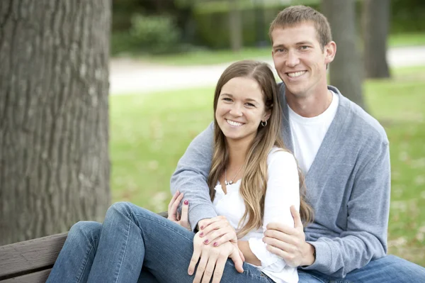 Couple sitting on a bench at the park — Stock Photo, Image