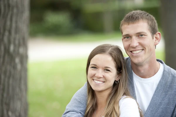 Couple sitting on a bench at the park — Stock Photo, Image