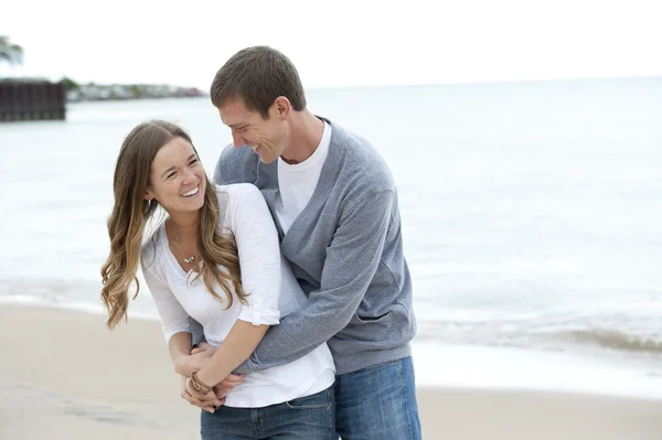 Jeune couple marchant sur la plage — Photo