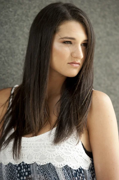 Brunette girl posing on a dark gray background — Stock Photo, Image