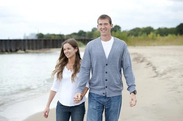 Pareja joven caminando en la playa — Foto de Stock