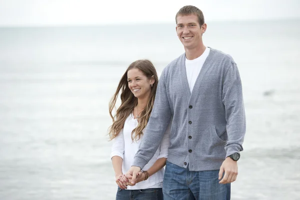 Pareja joven caminando en la playa — Foto de Stock