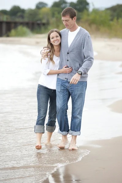 在海滩上散步的年轻夫妇 — 图库照片