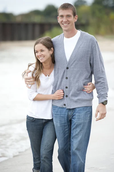 Jeune couple marchant sur la plage — Photo