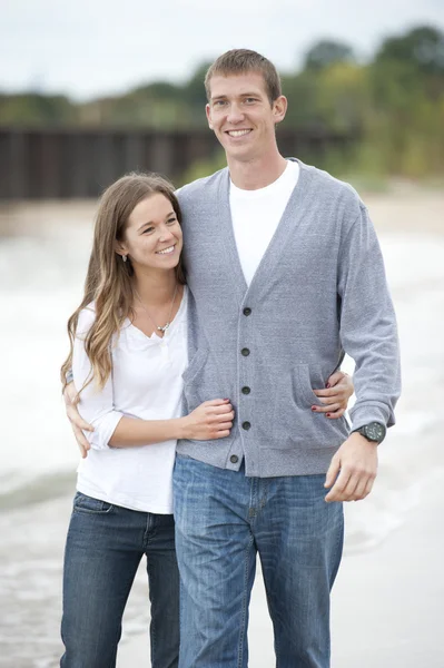 Pareja joven caminando en la playa — Foto de Stock