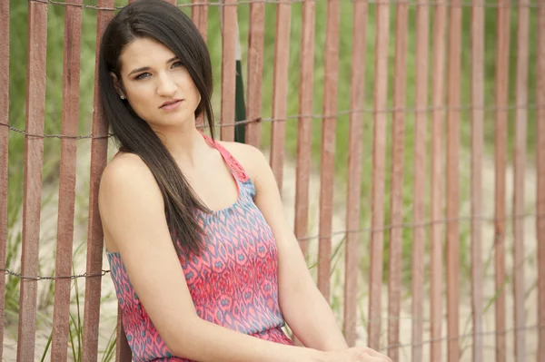 Modelo femenino sentado en la playa — Foto de Stock