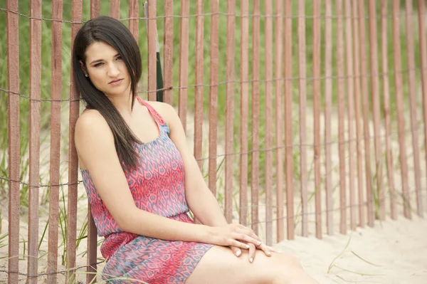 Kvinnlig modell sitter på stranden — Stockfoto