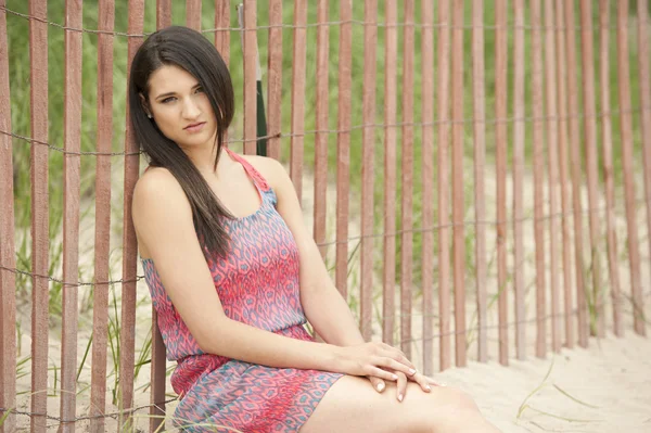 Modelo feminino sentado na praia — Fotografia de Stock