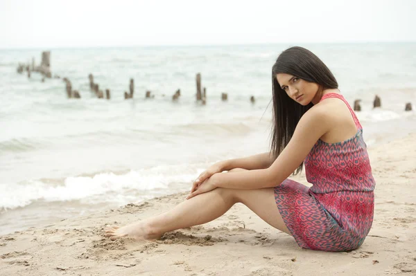 Modèle féminin assis à la plage — Photo