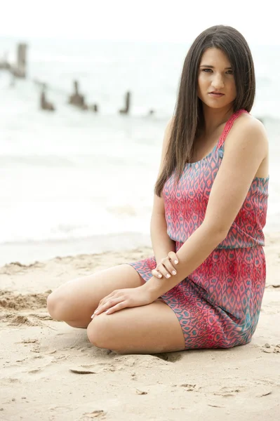 Женщина-модель сидит на пляже — стоковое фото