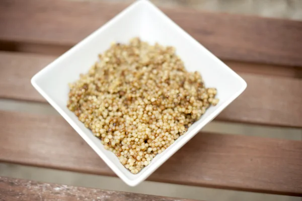 Israëlische couscous in een witte vierkante kom. — Stockfoto