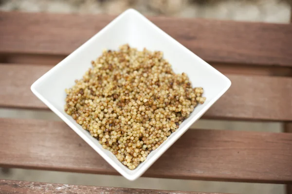 Israëlische couscous in een witte vierkante kom. — Stockfoto