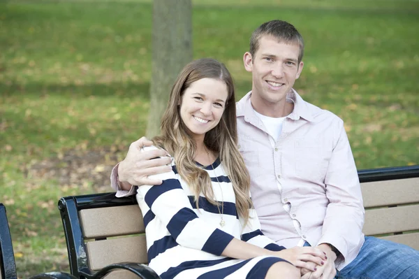 Couple sitting on a bench at the park Stock Image