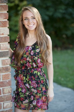 Esmer kız bir tuğla duvara yakın poz