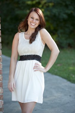 Genç esmer bir tuğla duvara yakın poz