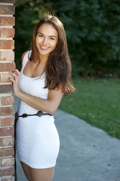 Brunette girl  posing near a brick wall — Stock Photo, Image