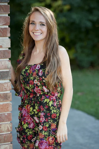 Brunette girl  posing near a brick wall — Stock Photo, Image