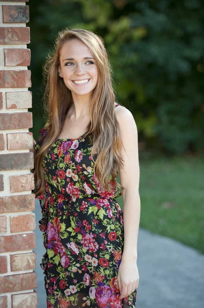 Brunette girl  posing near a brick wall — Stock Photo, Image