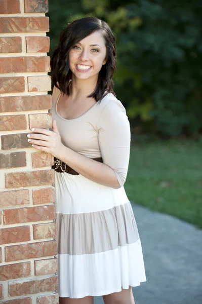 Brunette fille posant près d'un mur de briques — Photo