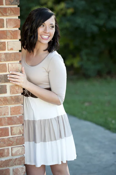 Brunette fille posant près d'un mur de briques — Photo