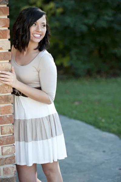 Brunette fille posant près d'un mur de briques — Photo