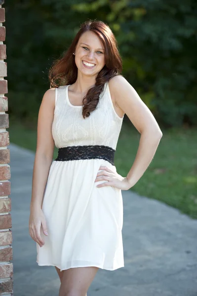 Young brunette posing near a brick wall — Stock Photo, Image