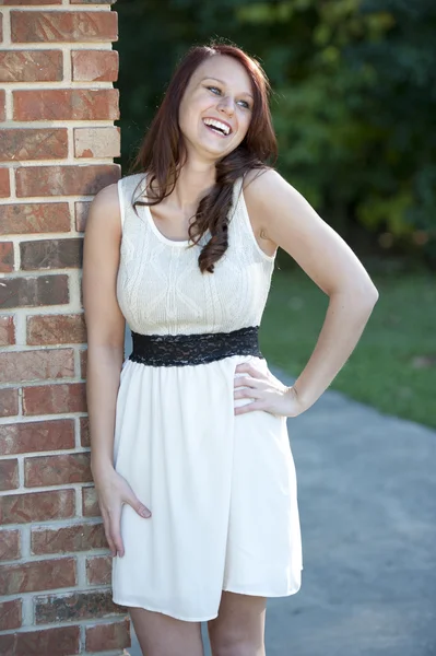 Young brunette posing near a brick wall — Stock Photo, Image