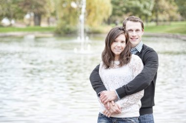 Genç çift gölün yanında poz