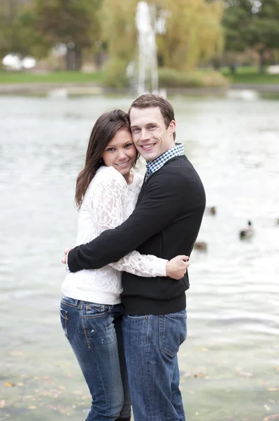 Jeune couple posant au bord de l'étang — Photo