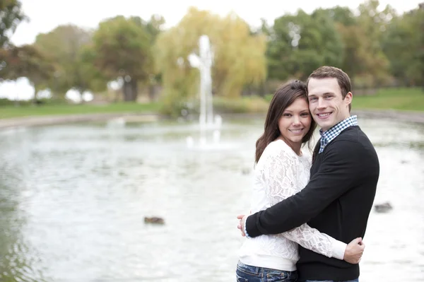 Jeune couple posant au bord de l'étang — Photo