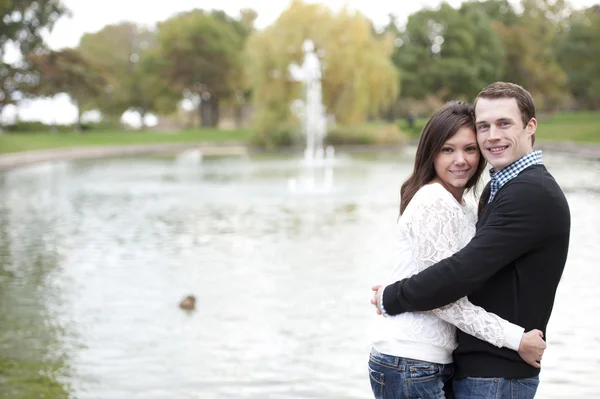 Mladý pár pózuje u rybníka — Stock fotografie