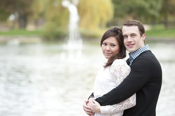 Jeune couple posant au bord de l'étang — Photo
