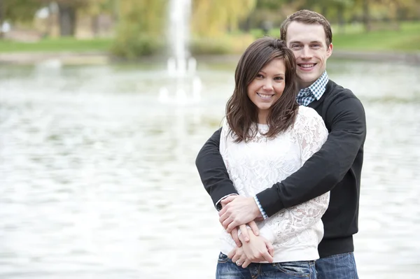Mladý pár pózuje u rybníka — Stock fotografie