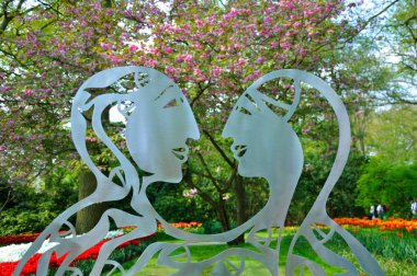Metalic statue of 2 lovers in Keukenhof park in Holland clipart
