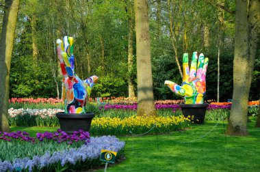 Groene Vingers (Big colorful hands) with tulips in Keukenhof par clipart